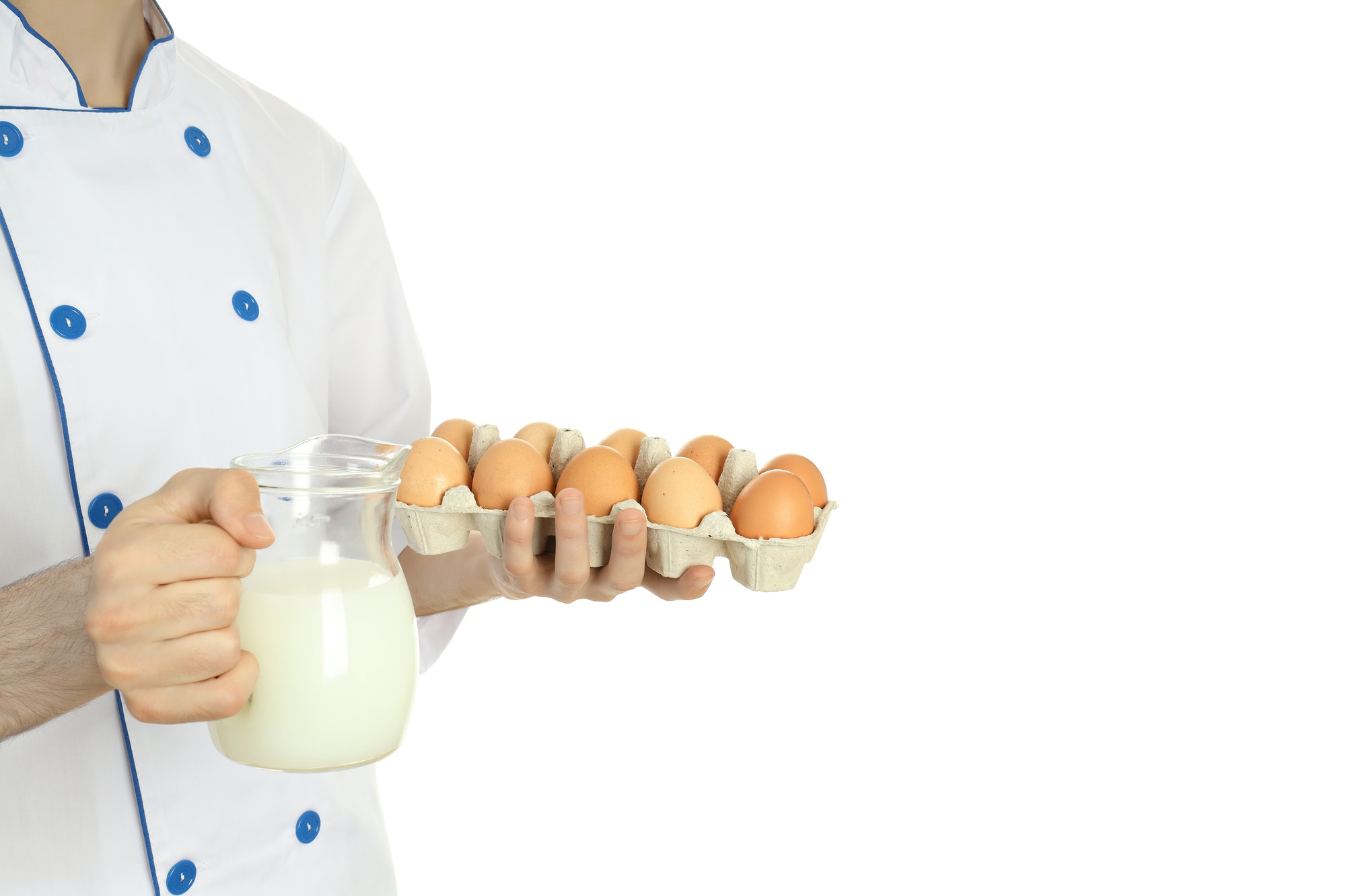 Young chef holds eggs and milk, isolated on white background