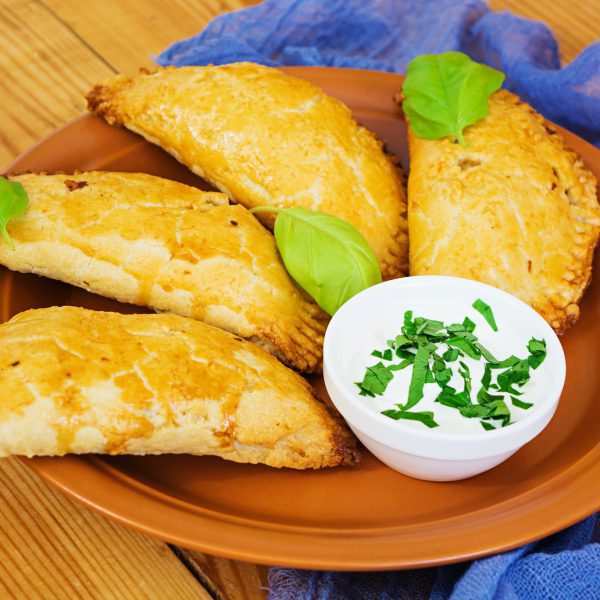 Baked empanadas on wooden background